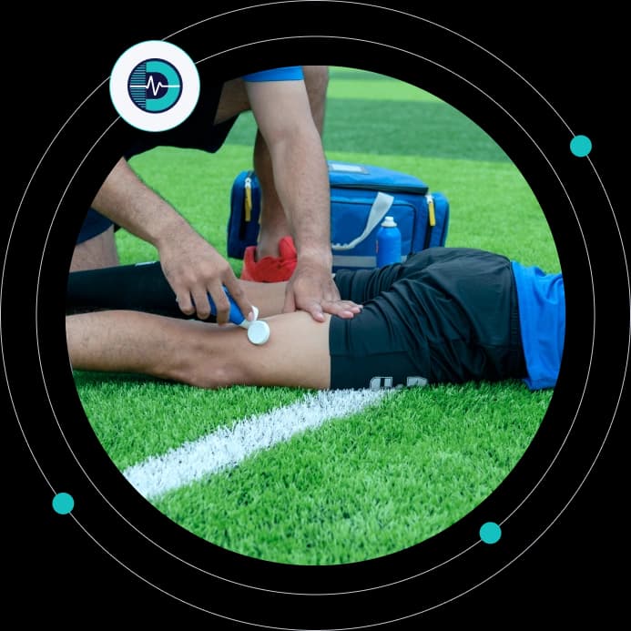 Pitch-side clinician treating an injured athlete's leg on the field