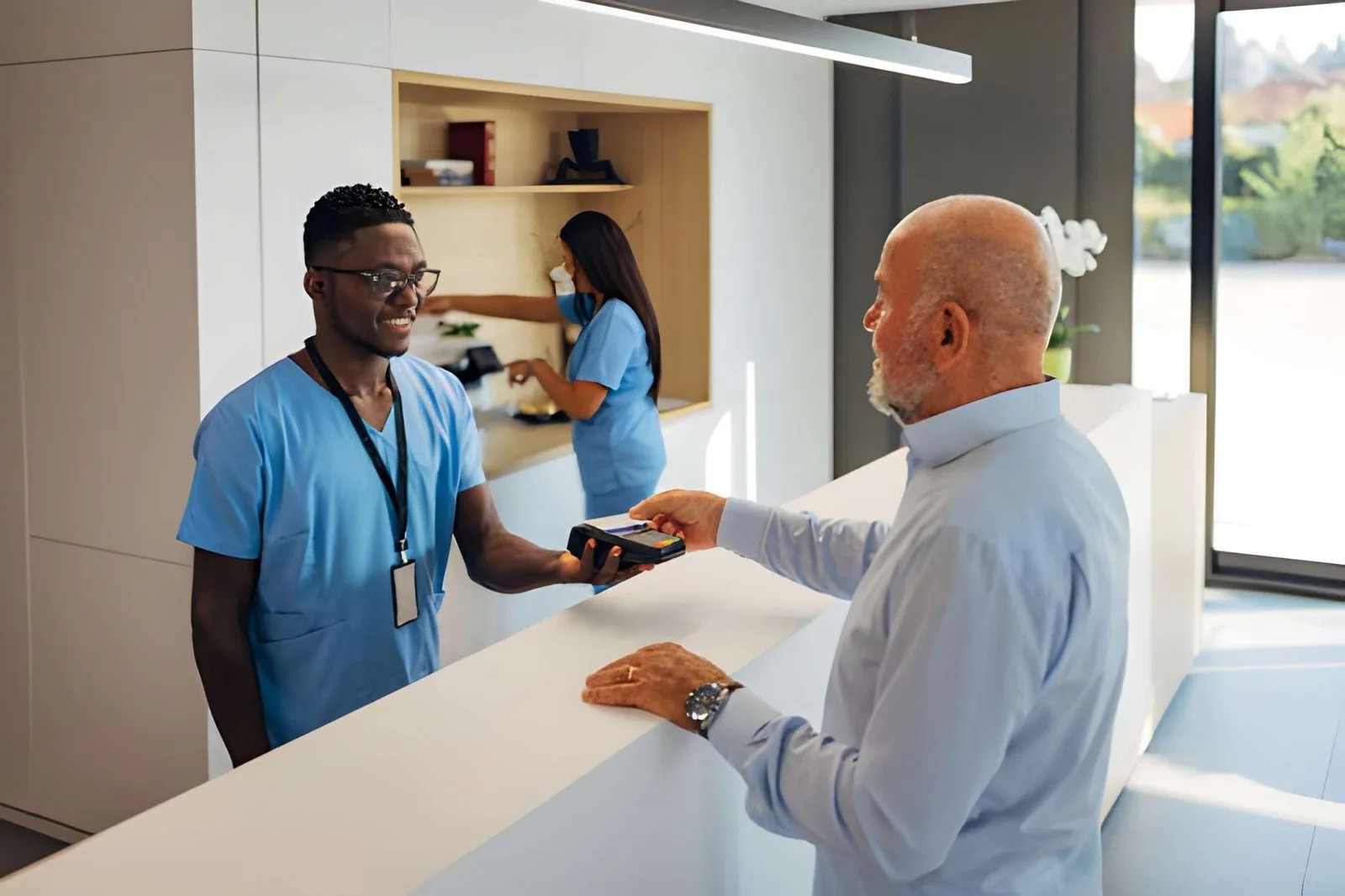 Patient paying a medical bill at a practice front desk