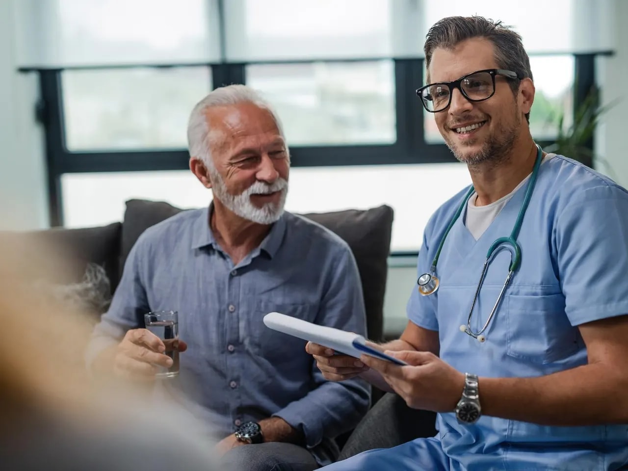 A physician reviewing practice paperwork with a smiling patient