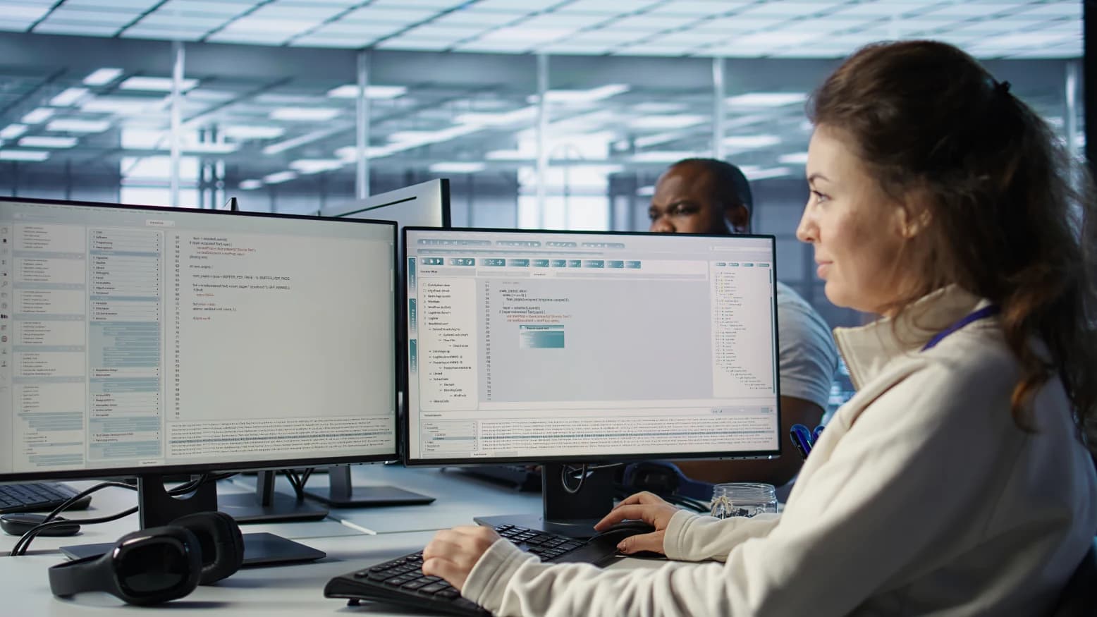 Clinician at a desk reviewing a medical claim on a laptop beside printed authorization paperwork