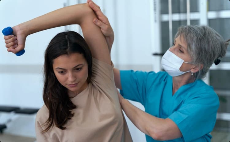 Physical therapist guiding a patient through a shoulder mobility exercise